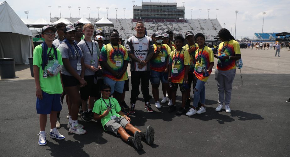 Kane Brown poses with Boys & Girls Club members in the infield at Nashville Superspeedway