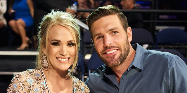 Carrie Underwood and husband Mike Fisher said faith gives them "a center ground." The couple attended the 2019 CMT Music Awards at Bridgestone Arena in Nashville, Tennessee.